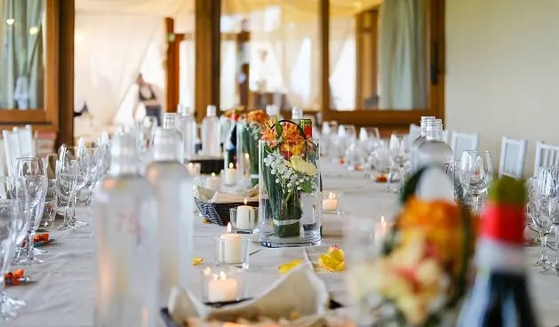 Mesa con arreglos florales y velas.