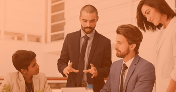 Equipo de profesionales en traje de negocios analizando proyecciones financieras en oficina moderna, ilustrando el impacto de la actuaría en la toma de decisiones estratégicas.