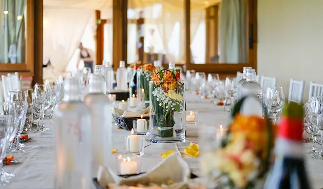 Mesa con arreglos florales y velas.