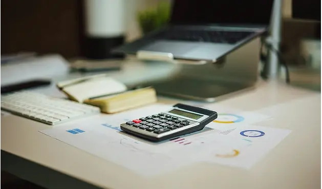 Calculadora y papeles sobre una mesa.