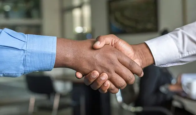 Imagen de dos personas dándose la mano.
