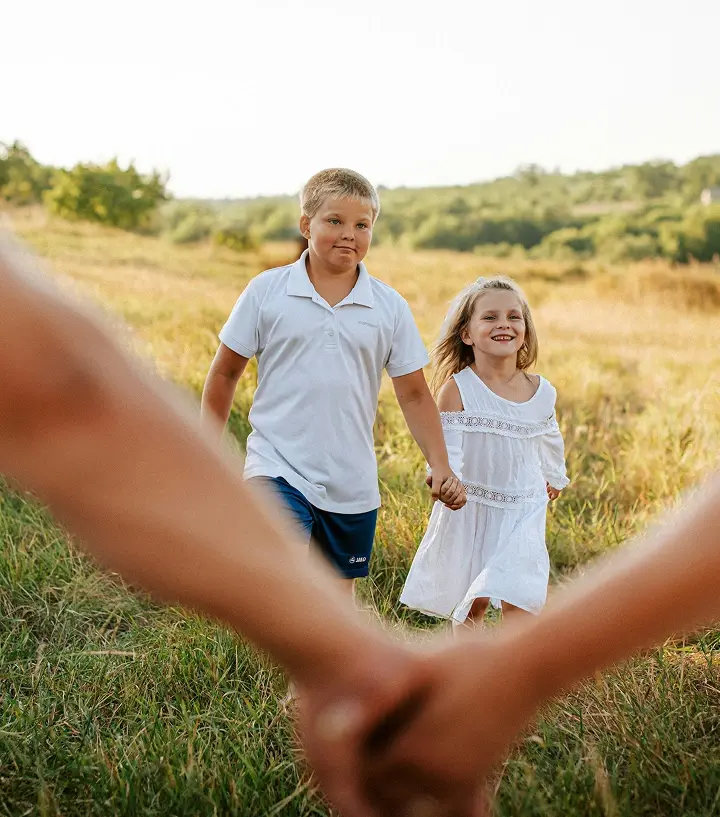 Dos niños caminando agarrados de la mano.