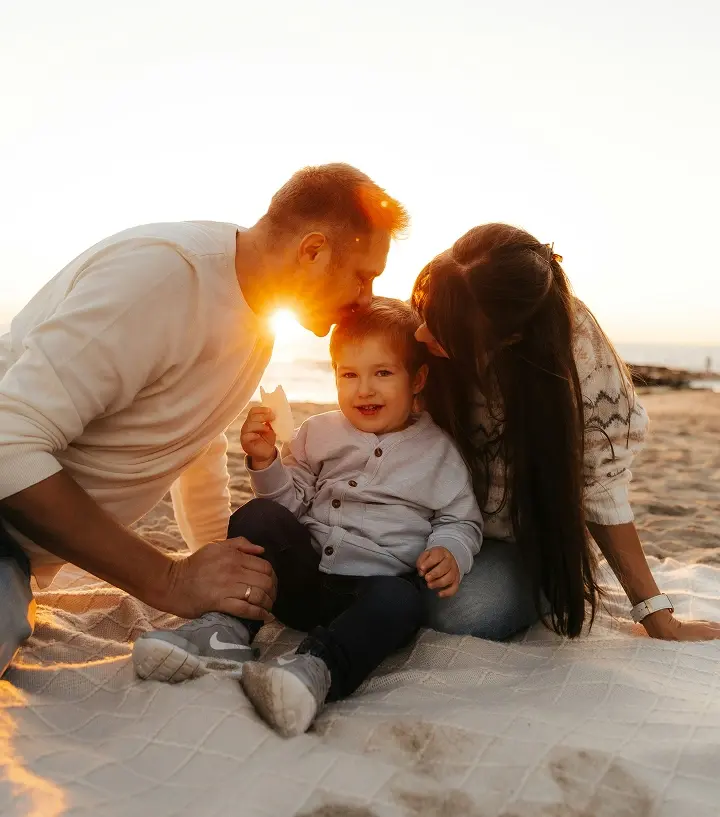 Familia sonriendo en la playa.