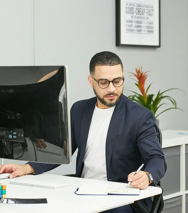 Hombre escribiendo con pluma sobre papel.