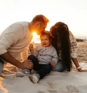 Familia sonriendo en la playa.
