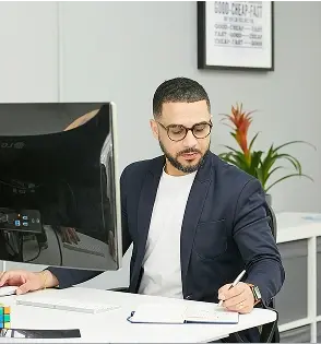Hombre escribiendo con pluma sobre papel.