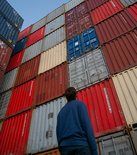 Hombre observando contenedores de negocios globales.