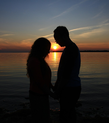 Pareja rezando junto al mar.