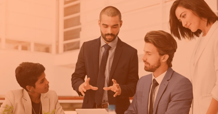 Equipo de profesionales en traje de negocios analizando proyecciones financieras en oficina moderna, ilustrando el impacto de la actuaría en la toma de decisiones estratégicas.